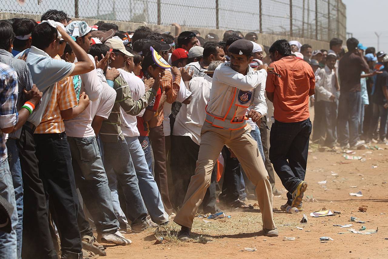 A policeman lathicharges fans queuing up outside the stadium in Motera, Ahmedabad, May 24, 2011