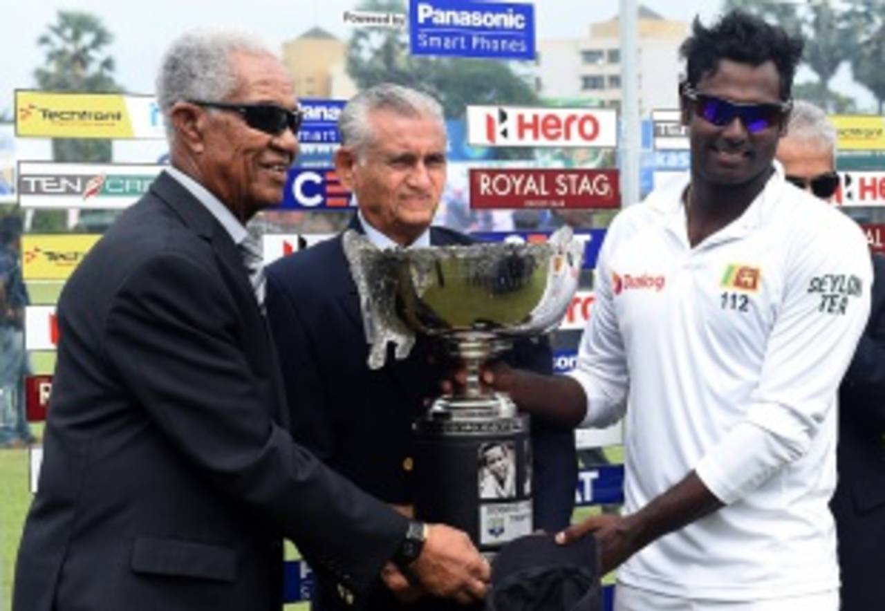 Angelo Mathews collects the trophy from Garry Sobers and Michael Tissera after winning the Test series 2-0&nbsp;&nbsp;&bull;&nbsp;&nbsp;AFP