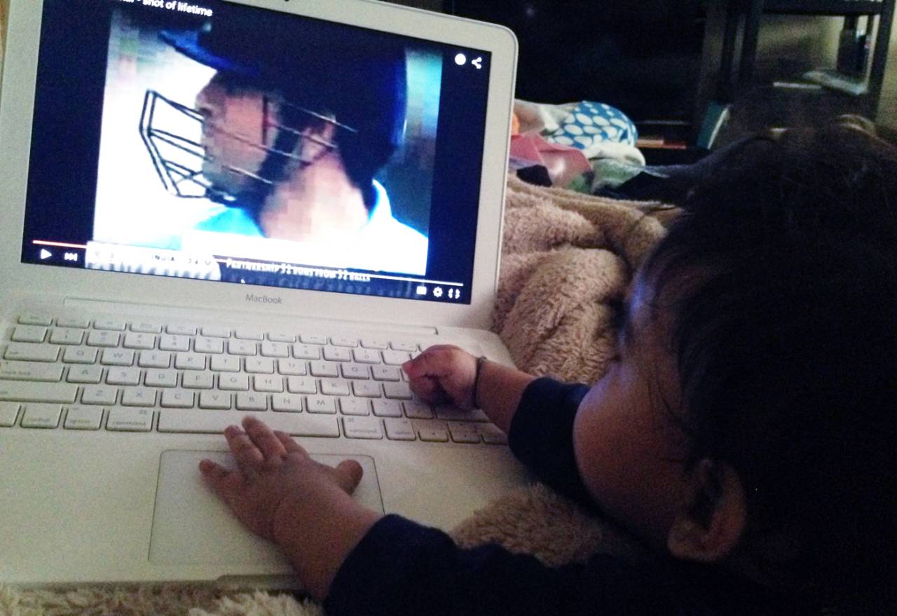 A child watches Sachin Tendulkar on a computer screen, 2015