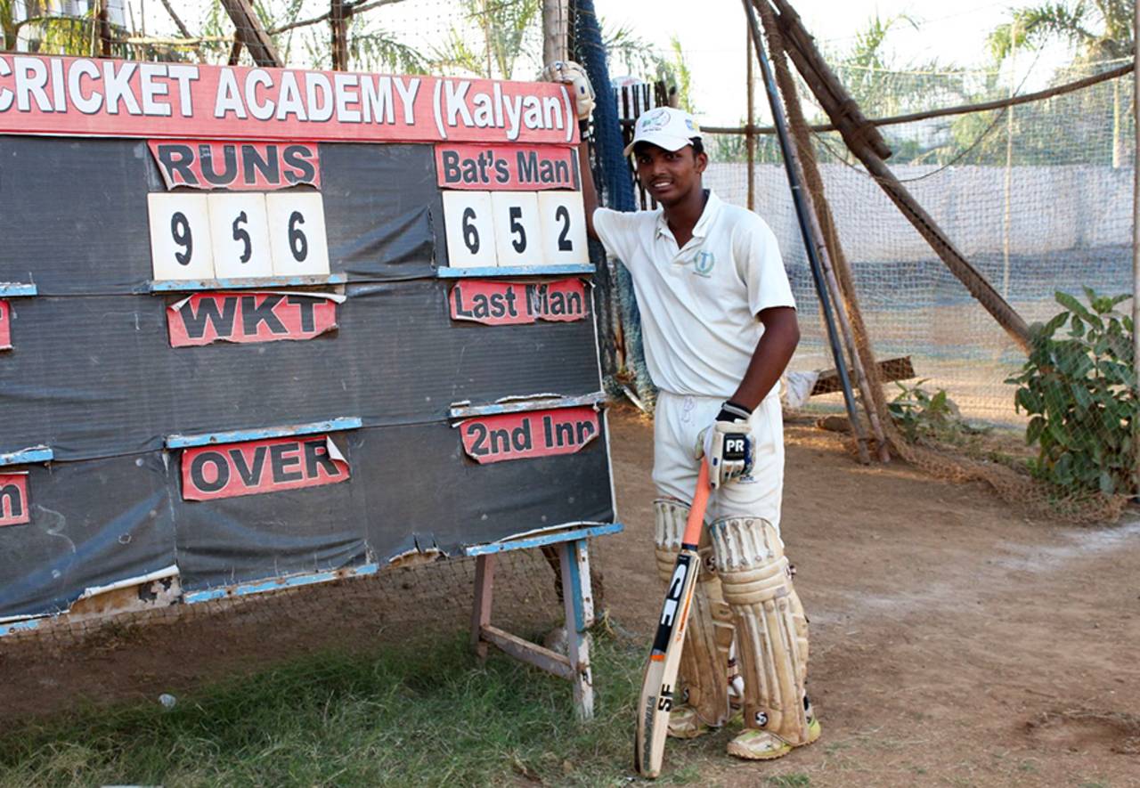 Dhanawade stands next to the scoreboard displaying his rather modest first-day total