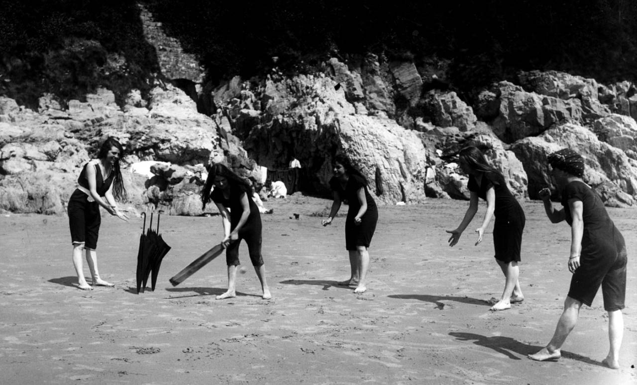 Young women play cricket on the beach at Swansea, 1910