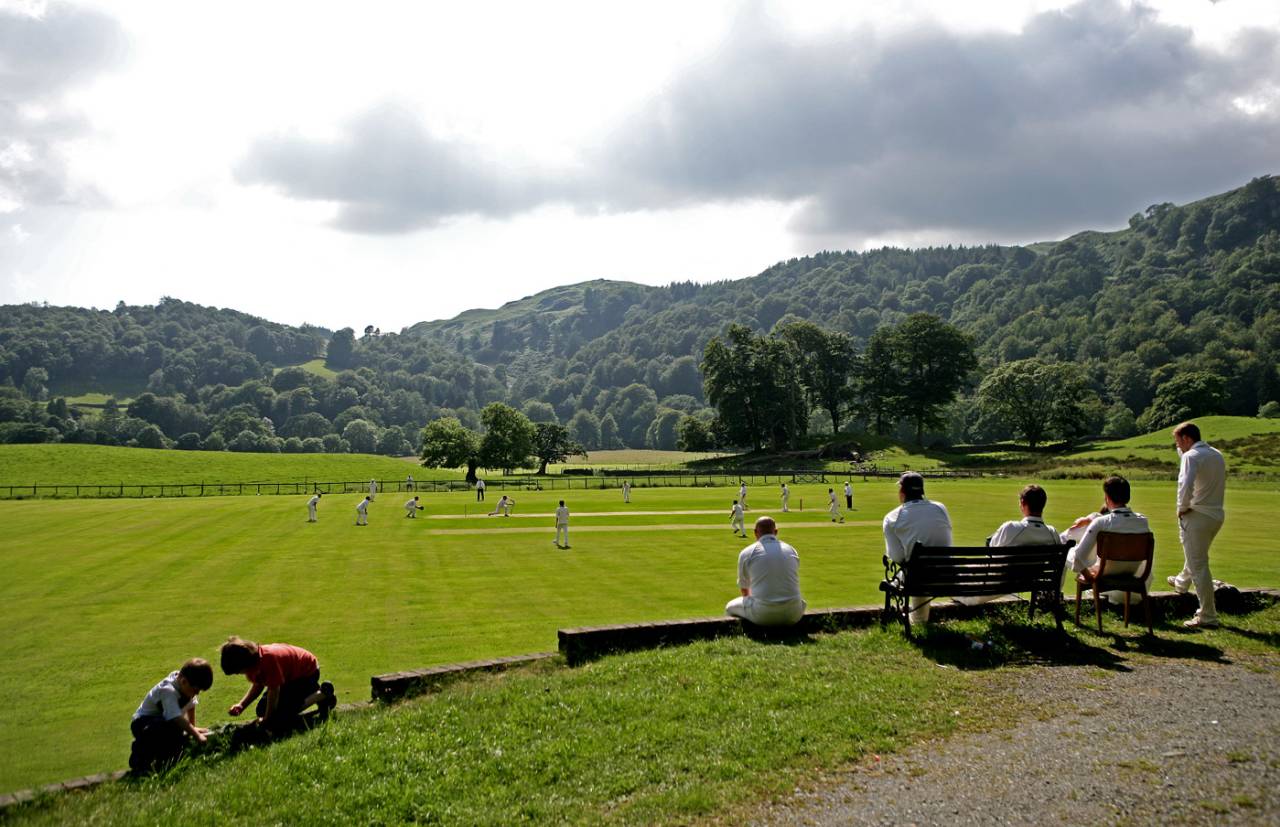 Players watch a game of village cricket from the boundary at Ambleside Cricket Club, July 26, 2008