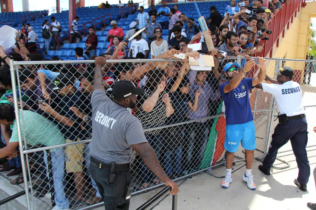 Security guards hold up a fence from collapsing under the weight of fans desperate for a selfie with Rohit Sharma, Lauderhill, August 26, 2016