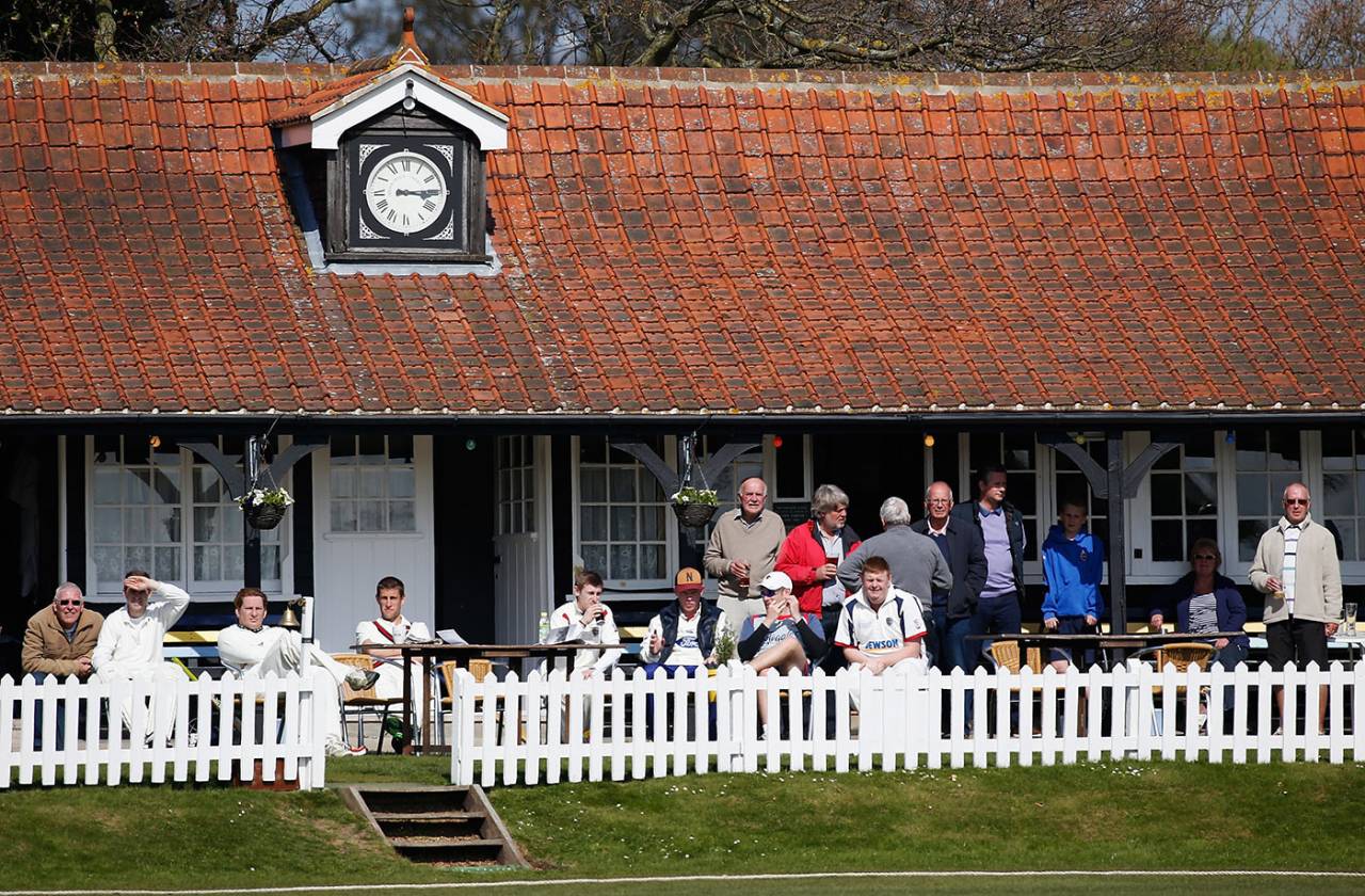 Players and spectators watch from the pavilion at a Two Counties Division One match, Frinton-on-Sea, April 19, 2014