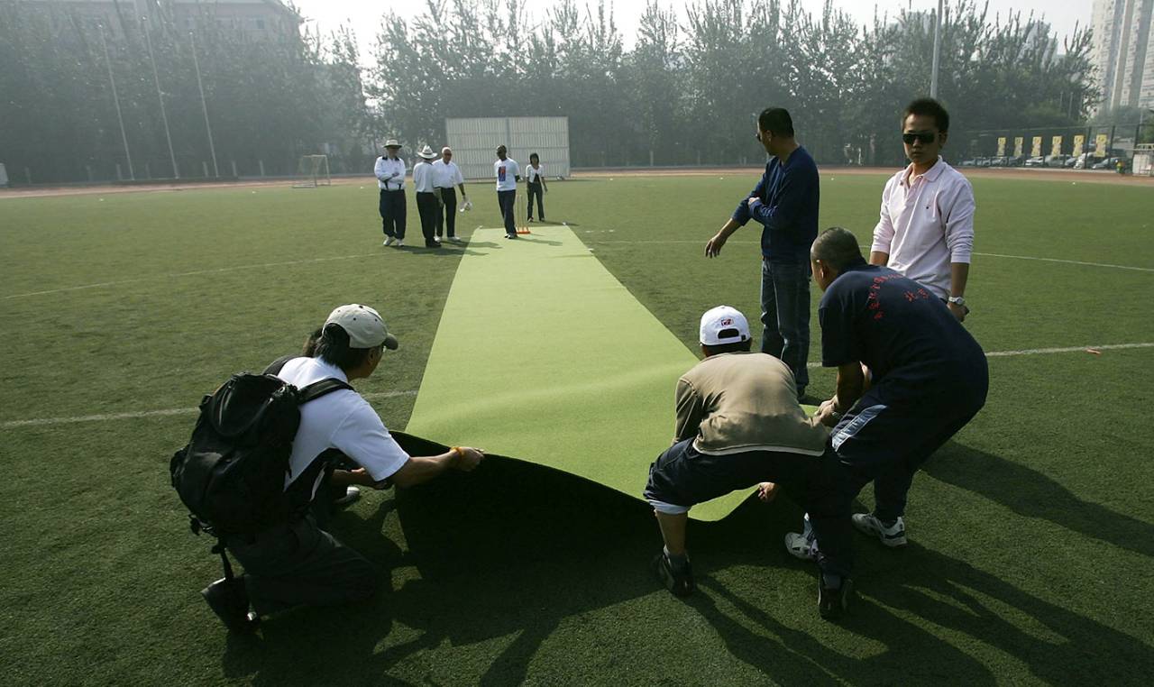Chinese students prepare an artificial pitch for the match between MCC and United Beijing XI, Beijing, October 1, 2006