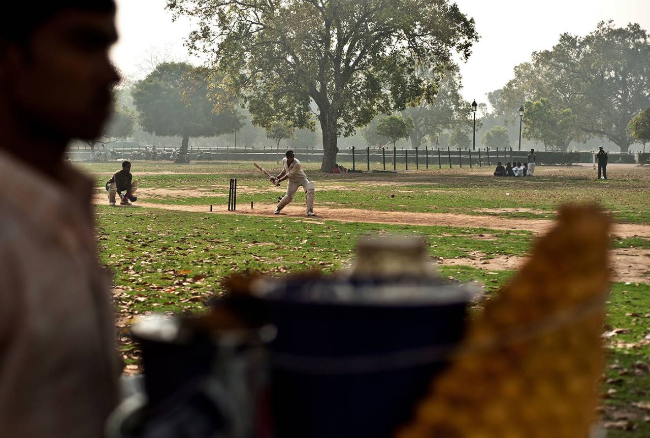 A street vendor sells delicacies while a cricket match is in progress on the lawns around India Gate, February 23, 2011
