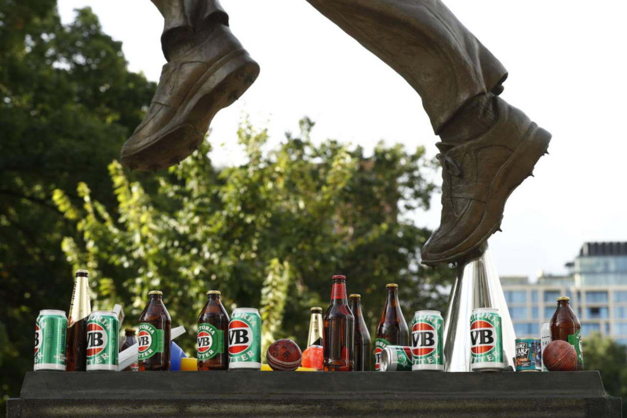Cans and bottles of beer, and tins of baked beans at the foot of the statue of Shane Warne at the MCG, March 5, 2022