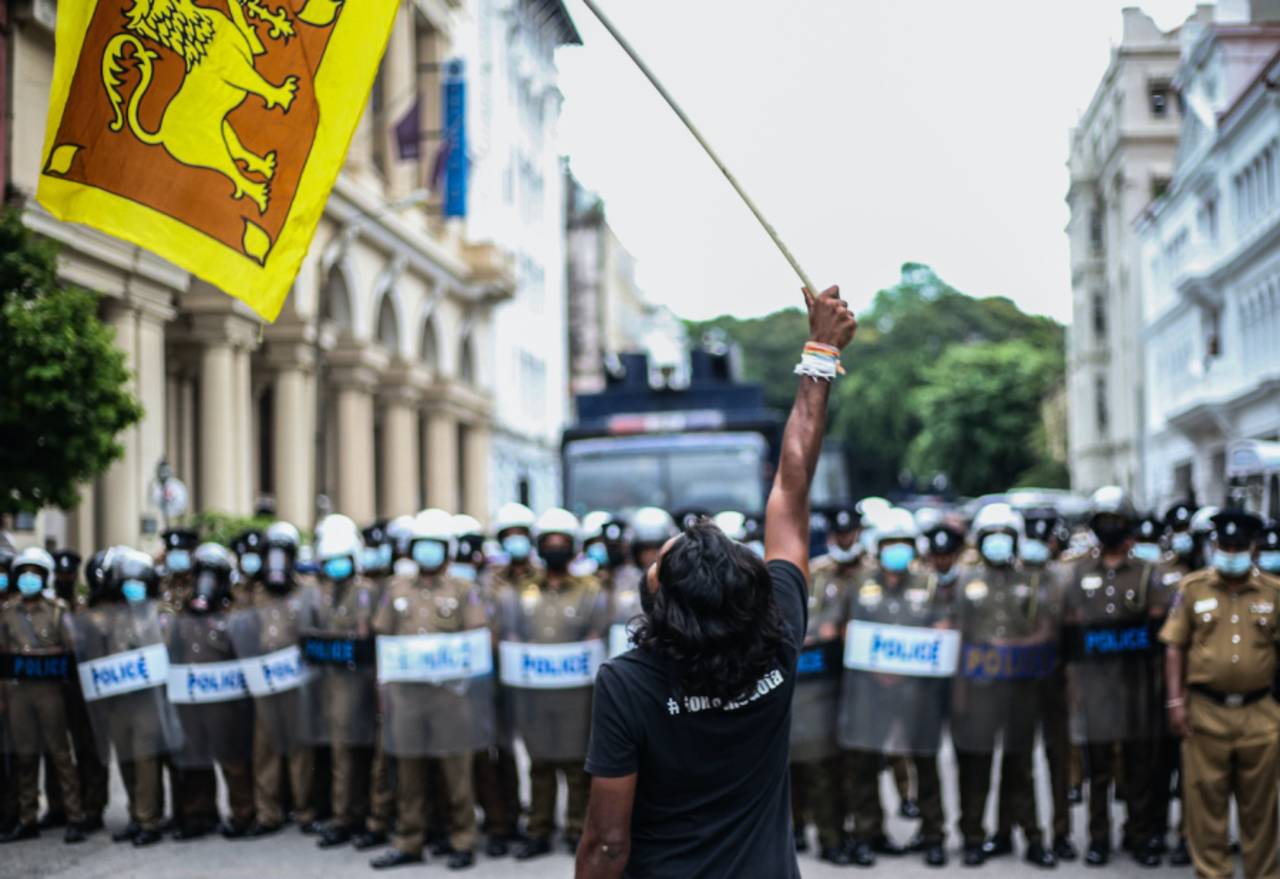 A protester waves the national flag in front of the police brigade during the protest near the president's house, Colombo, Sri Lanka, May 24, 2022