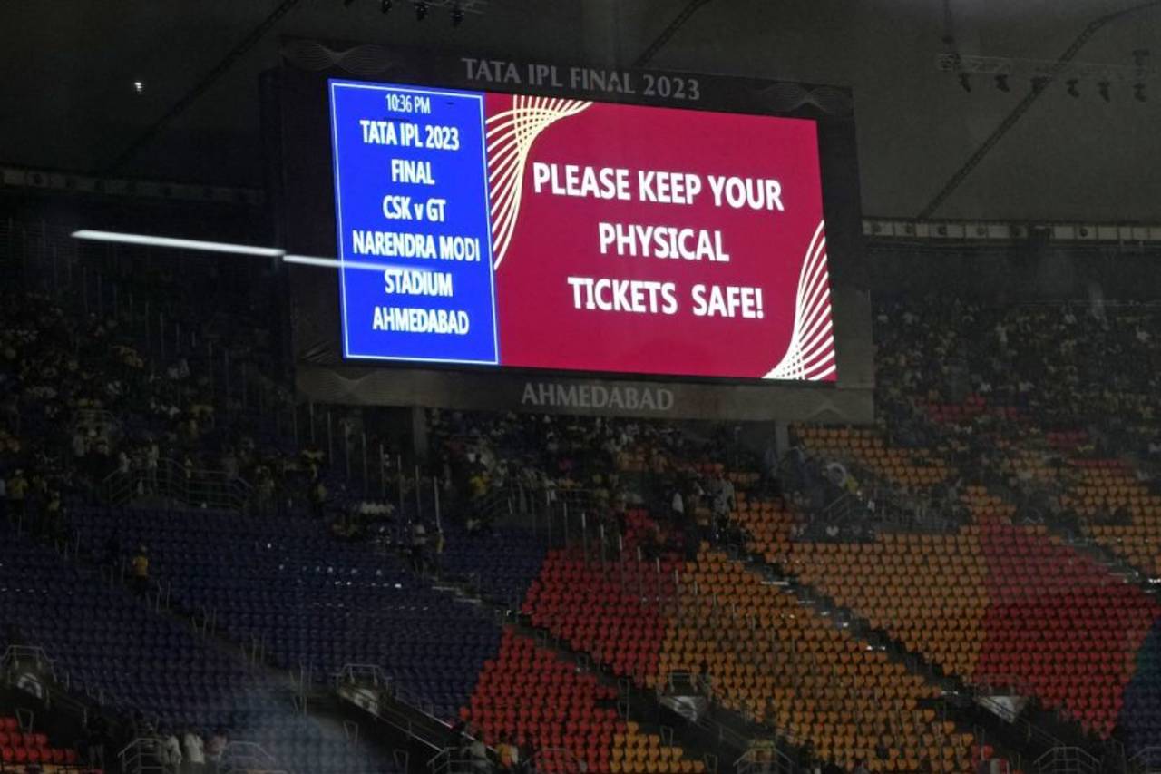 Fans are urged to keep their paper tickets safe as the rain comes down in Ahmedabad during the IPL final