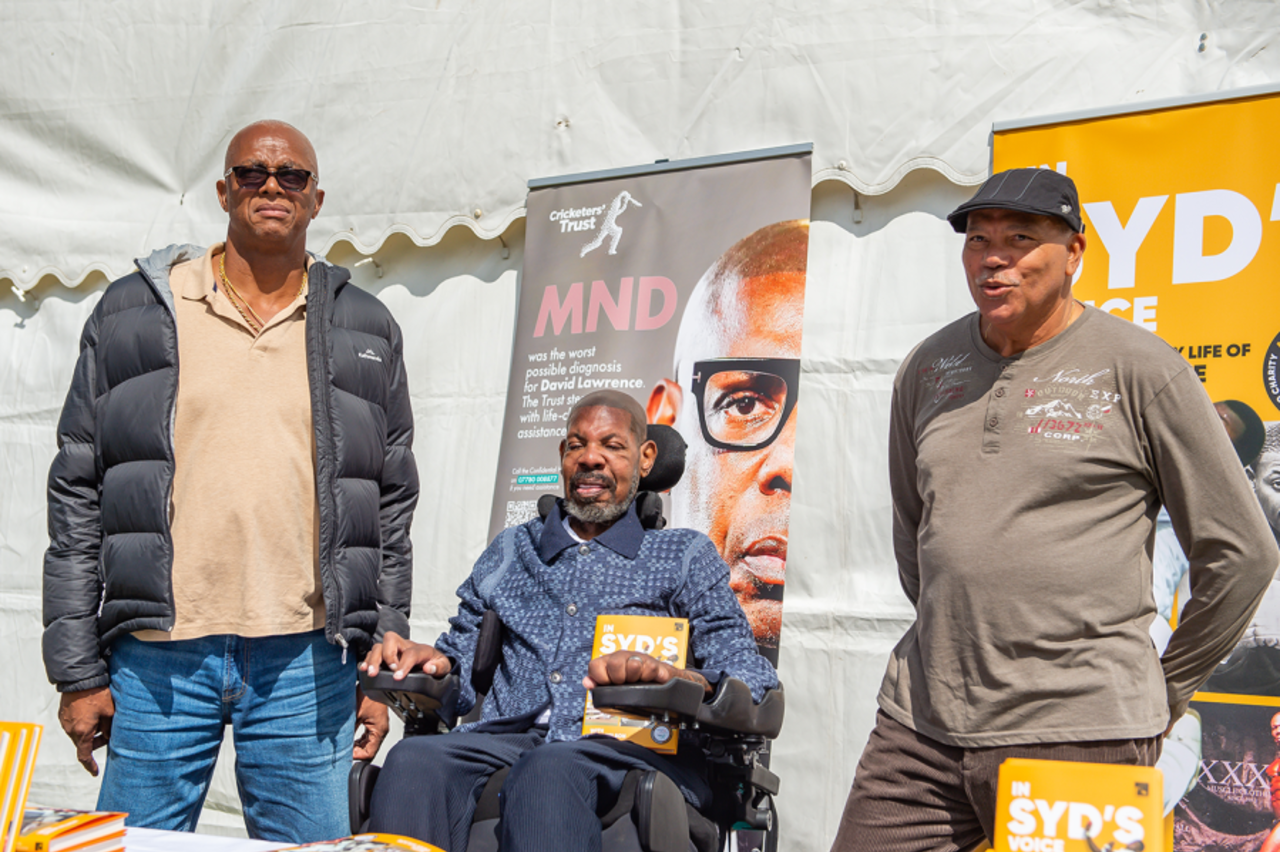 Courtney Walsh and David Lawrence (centre) pose with Lawrence's book <i>In Syd's Voice</i> at a charity event in Downend Cricket Club in Bristol, June 6, 2025