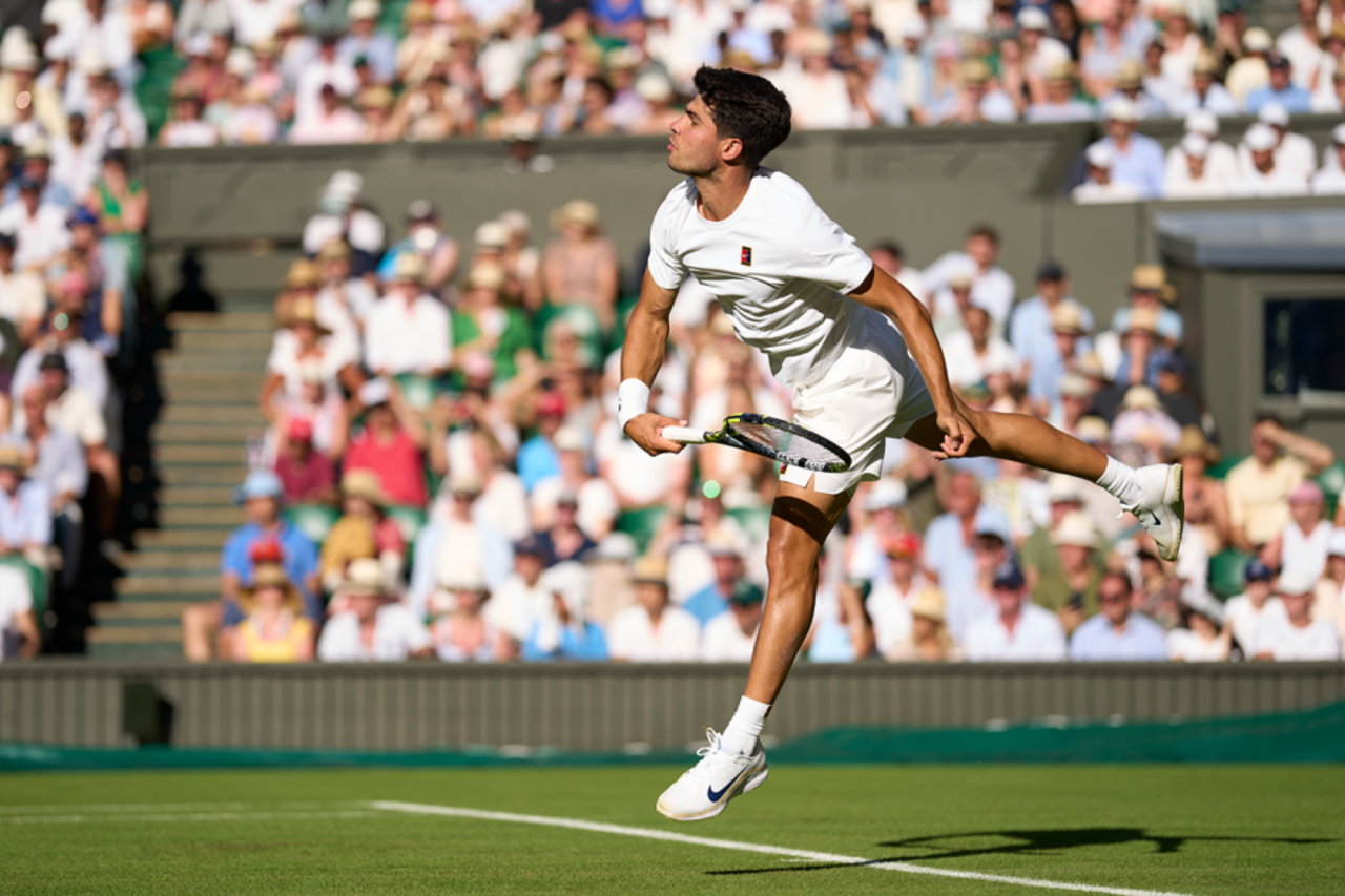 Carlos Alcaraz serves during his first-round match against Fabio Fognini at Wimbledon, Juen 30, 2025