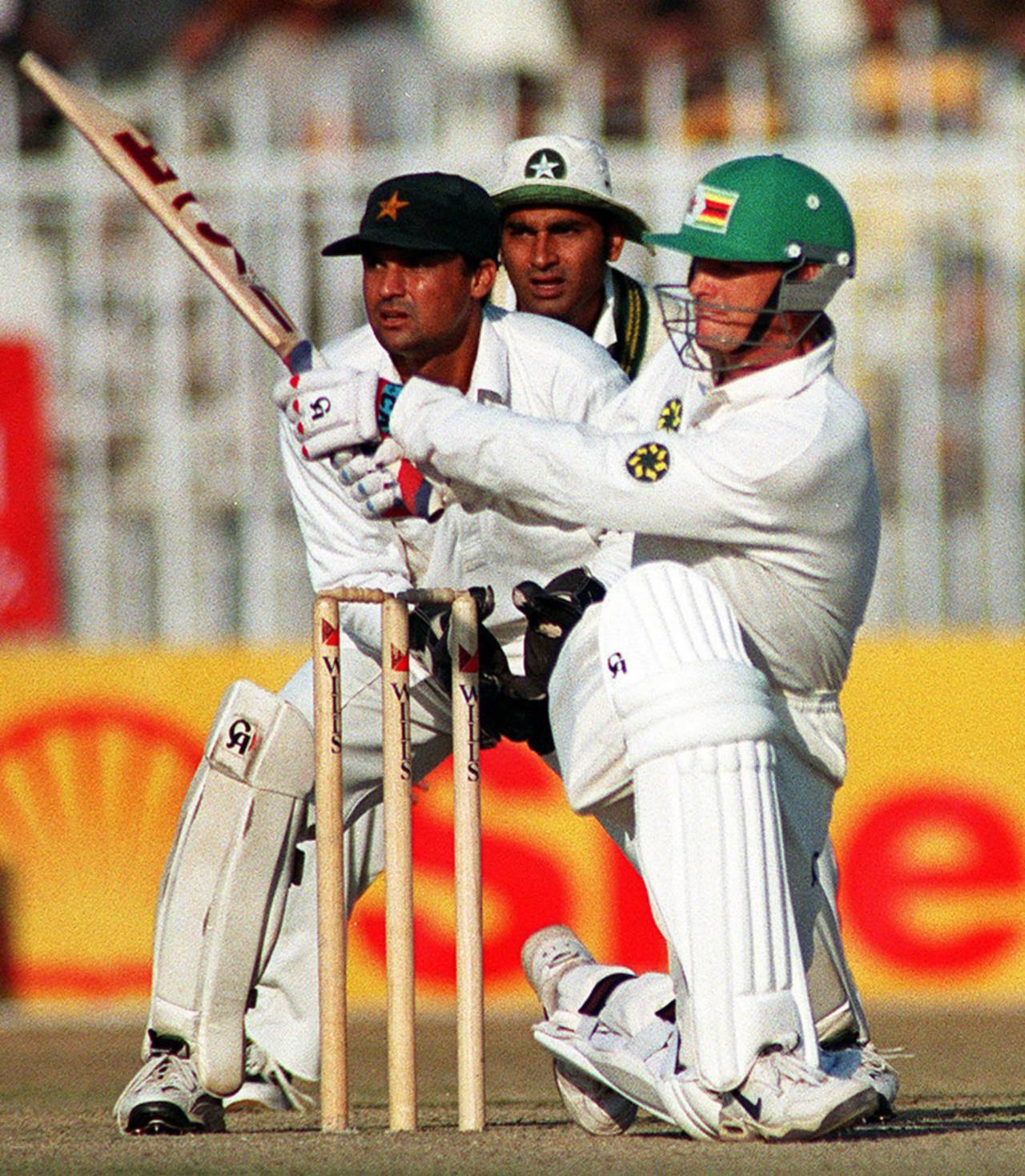 Pakistani skipper Aamir Sohail (C) and wicketkeeper Moin Khan (L) watch a boundary hit by Zimb abwe's Andy Flower in the third and final one-day international Cricket match in Rawalpindi 24 November 1998. Flower registered 61 in Zimbabwe's 191 for all out in reply to Pakistan's 302-6.