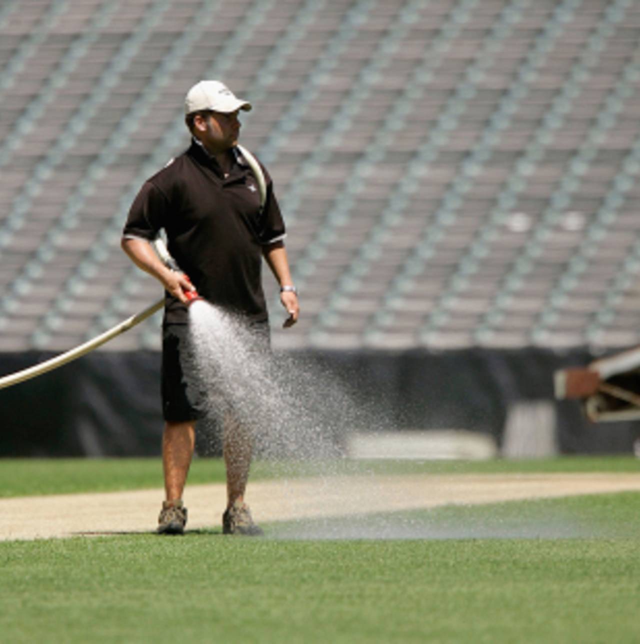 A groundsman waters the field during pitch preparations, Eden Park, Auckland, December 1, 2005