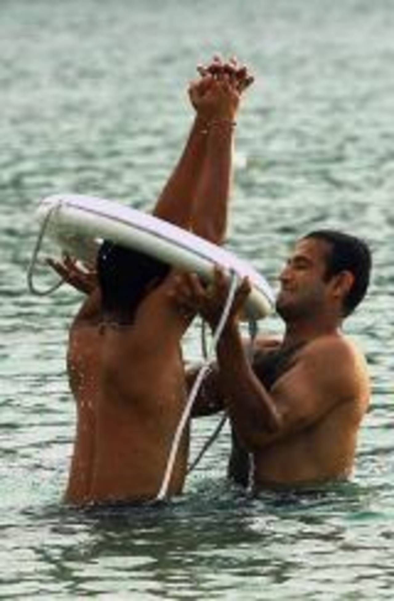 Irfan Pathan helps Suresh Raina out of a life buoy as they swim in the sea at Rodney Bay, St Lucia, June 9, 2006.