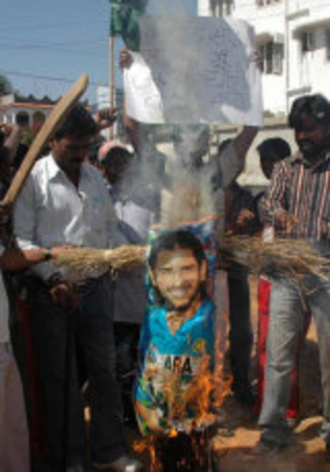 Indian protestors burn a poster of cricketer Mahendra Singh Dhoni outside his home in Ranchi, March 18, 2007
