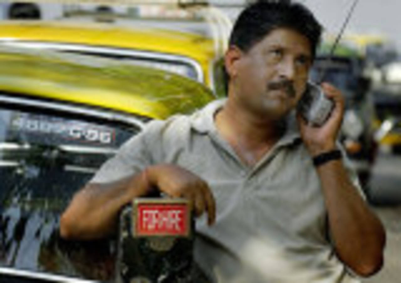 A taxi-driver follows cricket on the radio, March 13, 2004