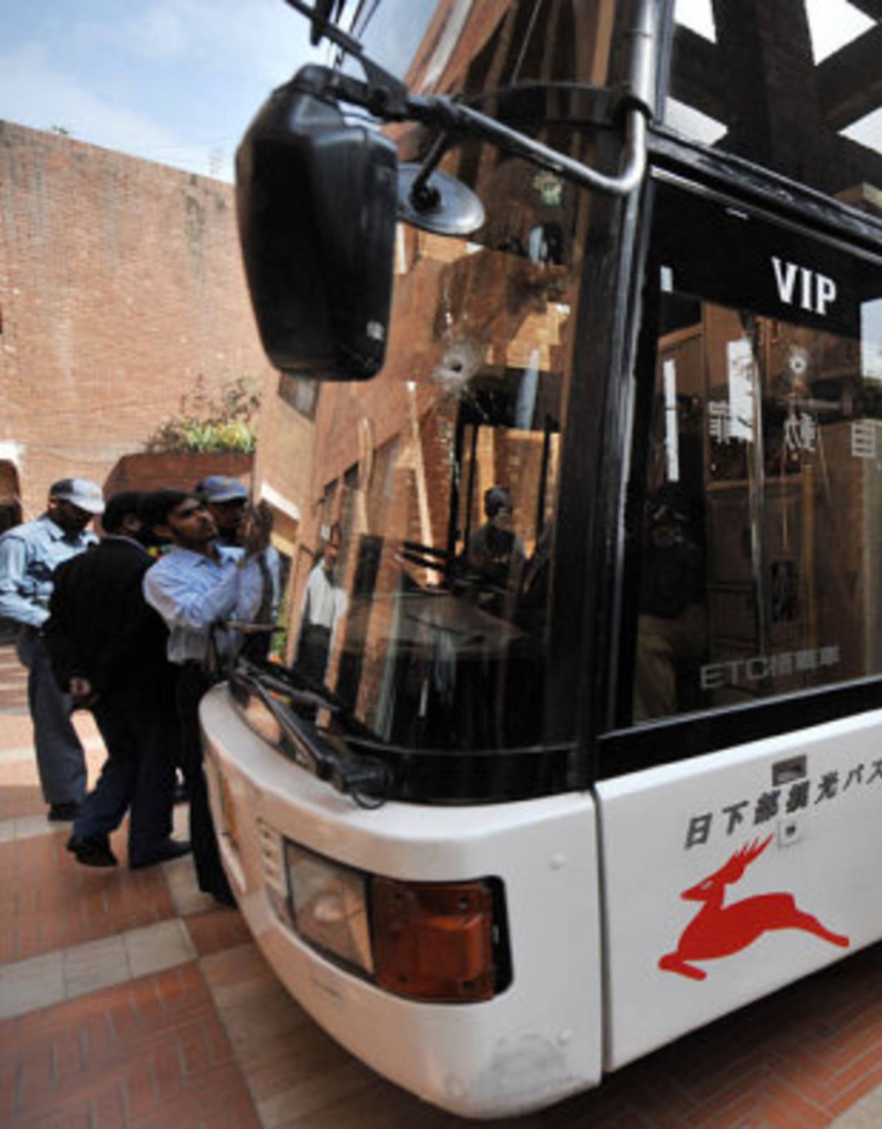 Security guards crowd round the Sri Lankan team's bullet-ridden bus, Lahore, March 3, 2009