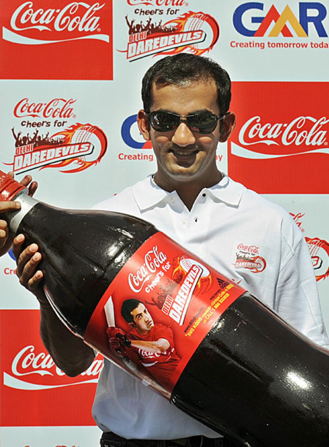 The new face of Coca Cola, Gautam Gambhir, poses with a giant bottle, New Delhi, April 11, 2009