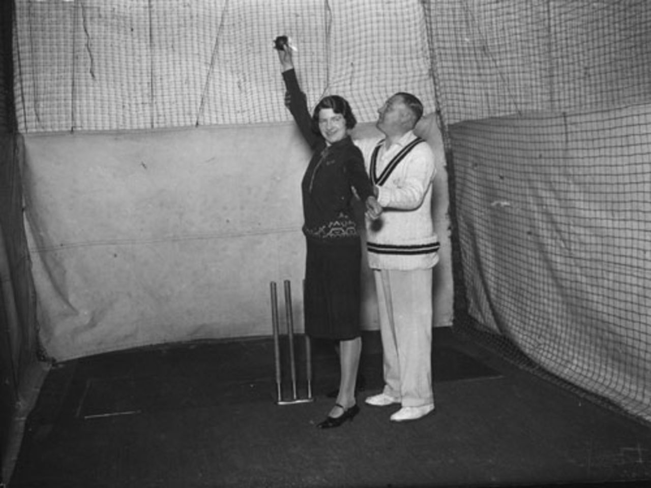 Surrey cricketer Bert Geary shows a female pupil how to bowl overarm at a Winter cricket school, 3 November, 1931