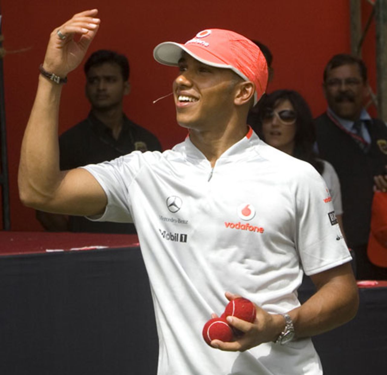 Reigning Formula One world champion Lewis Hamilton throws autographed tennis balls into the crowd at a promotional event in Delhi, August 1, 2009