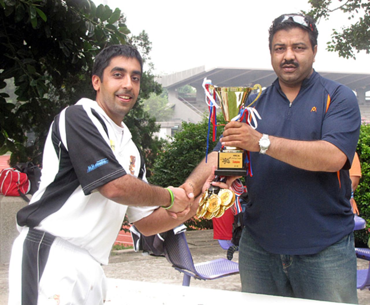 Romy Mangat, captain of Taipans CC, receives the Challenge League trophy and winners medals from Muhammeed Ilyas Alex 
