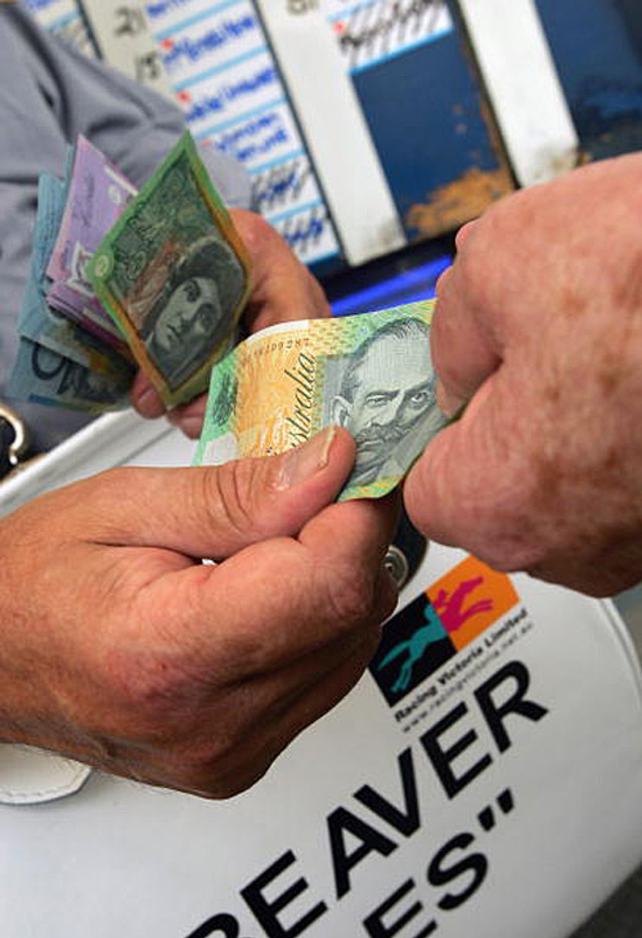 Money changes hands by bookmakers at a race, November, 2005