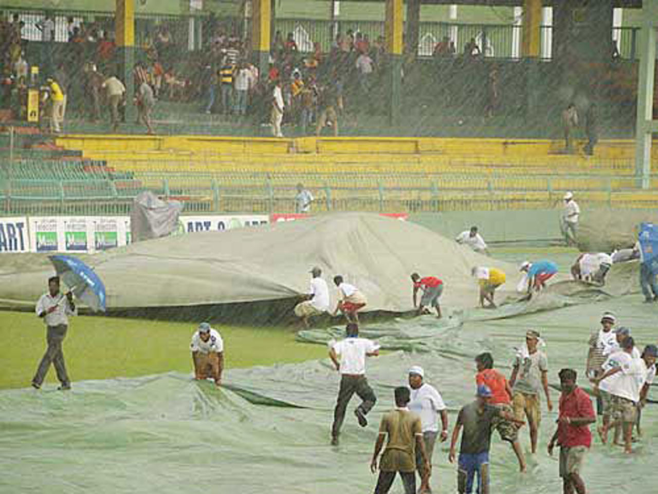 The groundstaff cover the ground during a rain shower, Colombo, September 4, 2009