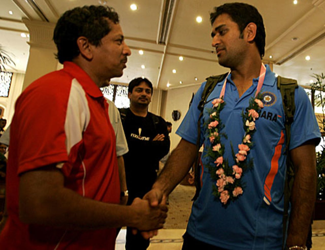 MS Dhoni shakes hands with a reporter at the team hotel as Cricinfo's former associate editor Anand Vasu looks on, Colombo, September 9, 2009