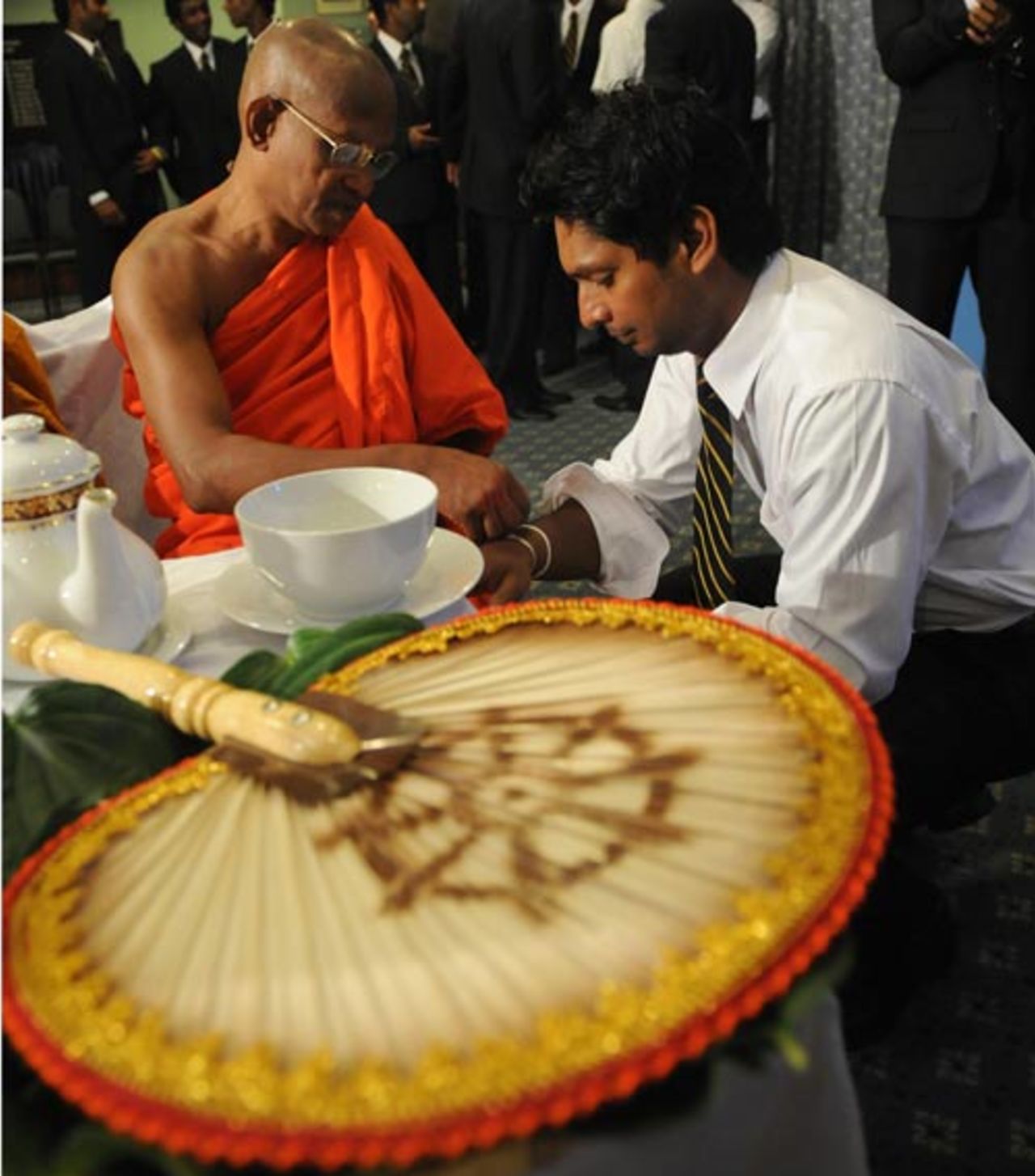 A Buddhist monk ties a sacred white thread around Kumar Sangakkara's wrist at a ceremony in Sri Lanka Cricket's headquarters, Colombo, September 16, 2009