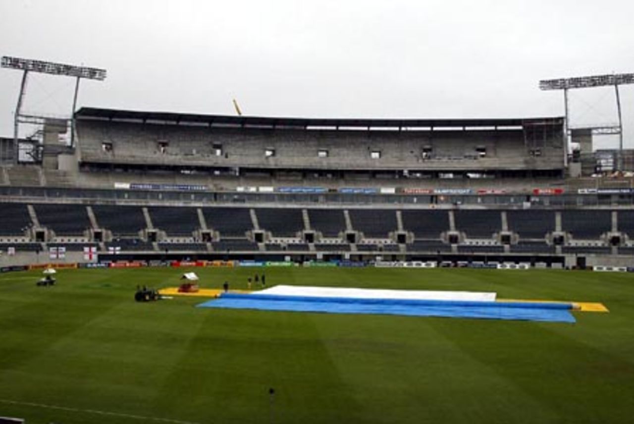 The new West Stand in the background with the covers are on the pitch as rain delays the start of play on day two. 1st Test: New Zealand v England at Jade Stadium, Christchurch, 13-17 March 2002 (14 March 2002).