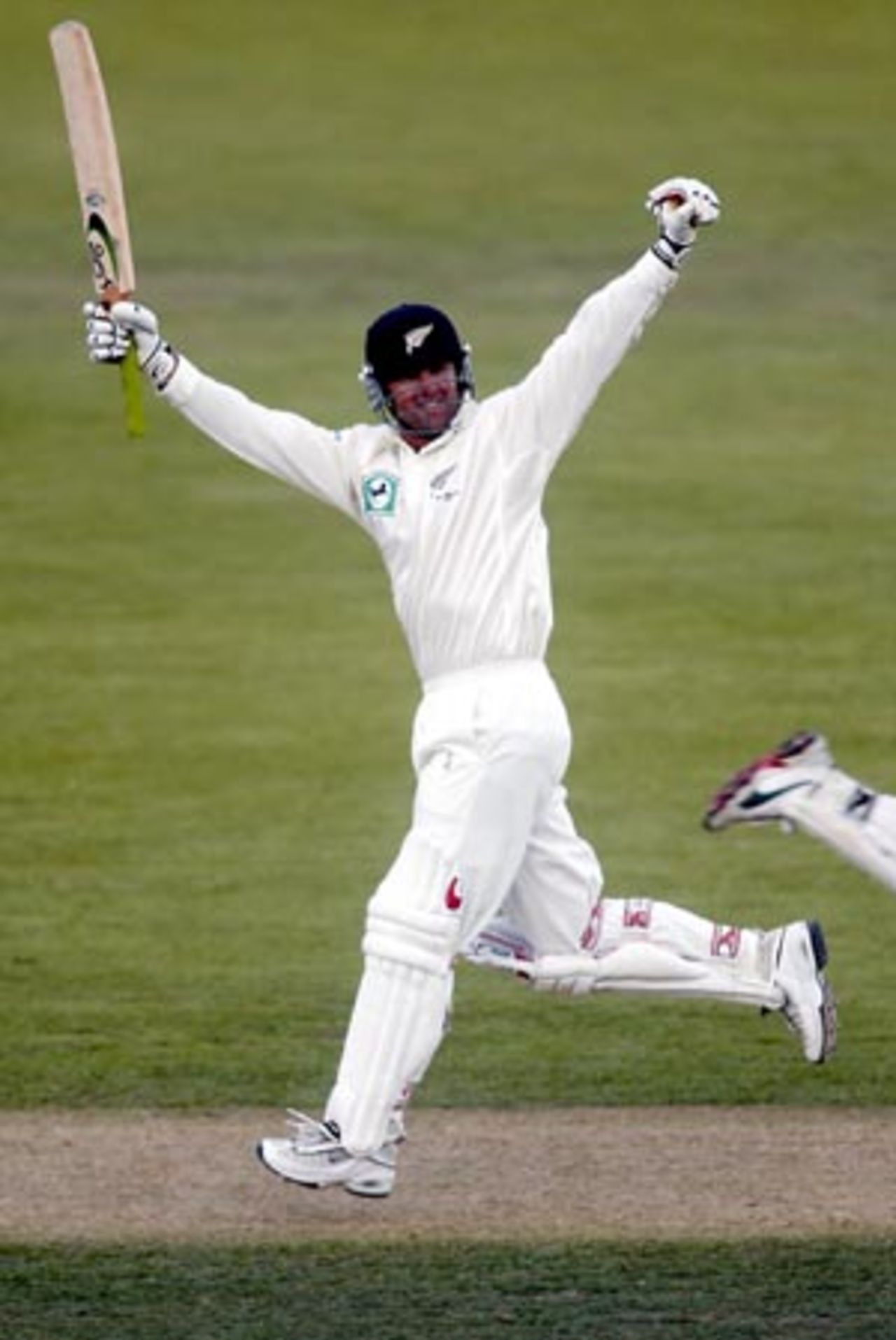 New Zealand batsman Nathan Astle raises his arms to celebrate reaching his double century. Astle went on to score 222 in his second innings. 1st Test: New Zealand v England at Jade Stadium, Christchurch, 13-17 March 2002 (16 March 2002).