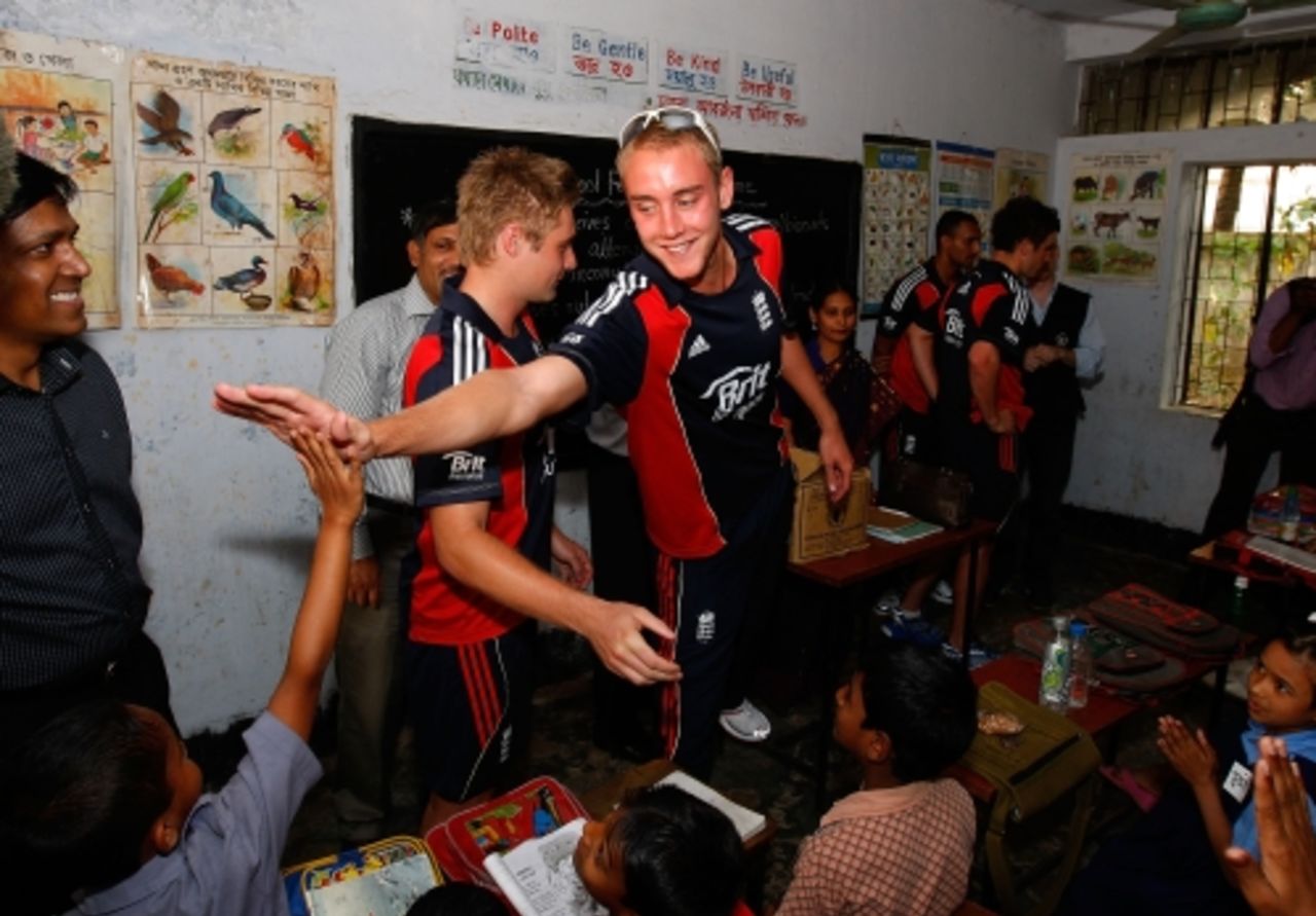 Stuart Broad and other members of the England cricket team meet children during a visit to Sher-e-Bangla primary school, February 26, 2010