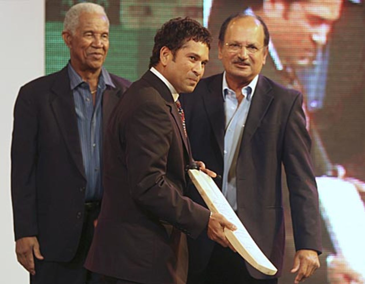 Sachin Tendulkar holds an autographed bat presented to him, as Ajit Wadekar and Garry Sobers look on, Mumbai, March 4, 2010