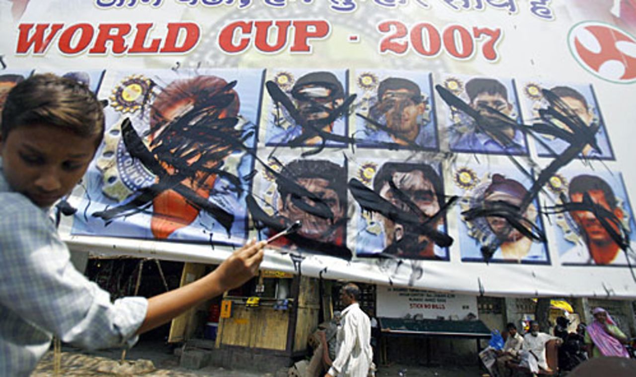 An Indian cricket fan uses black paint to deface pictures of Indian cricketers, Mumbai, March 24, 2007