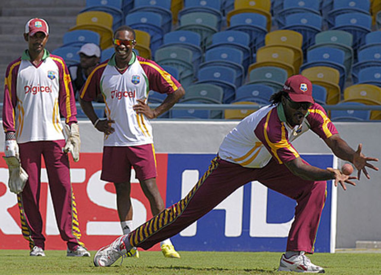Chris Gayle takes a catch during fielding practice as Denesh Ramdin and Dwayne Bravo look on, Barbados, June 24, 2010