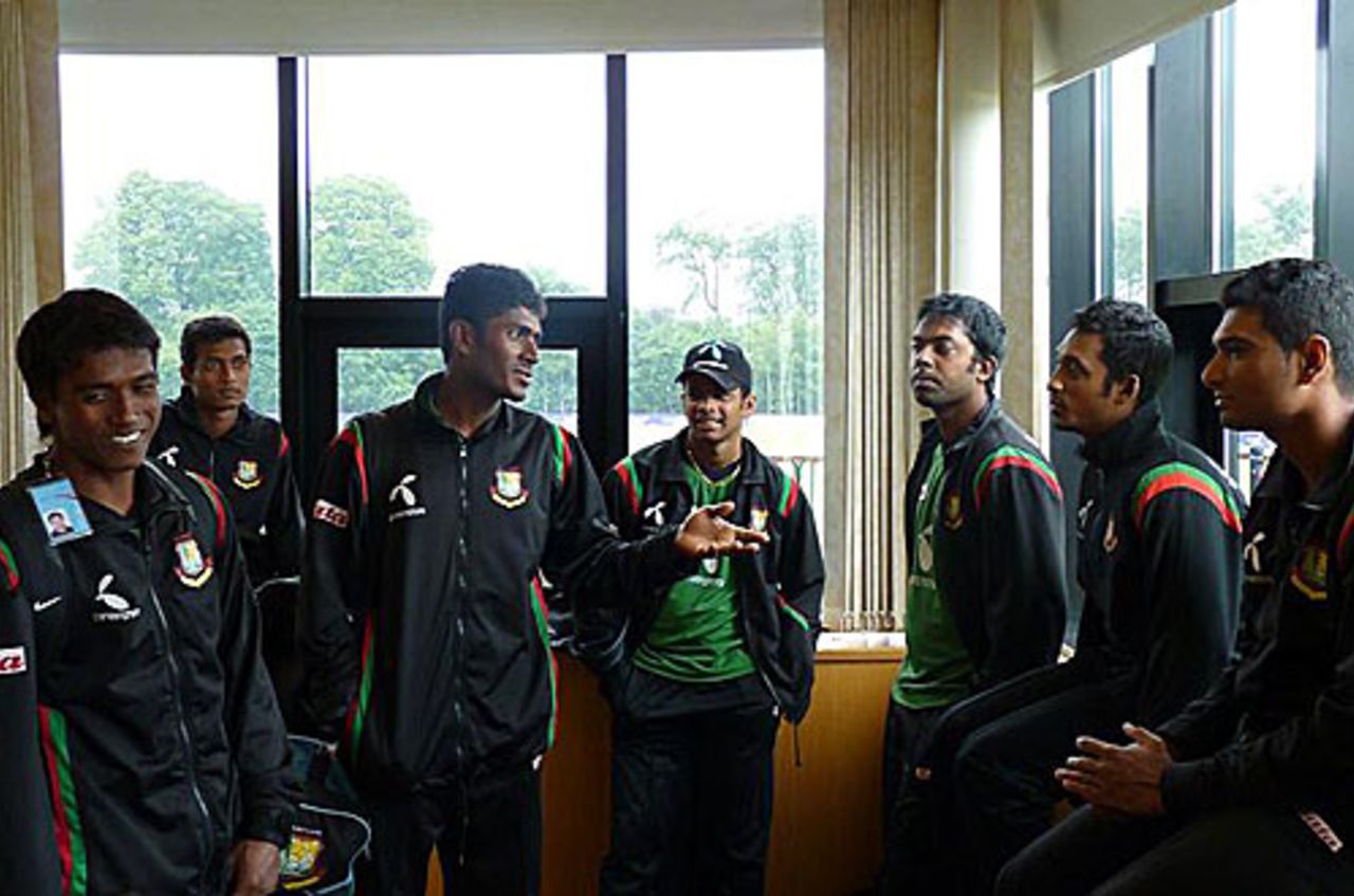 Jahurul Islam chats with his team-mates as the players are forced indoors, Belfast, July 14, 2010