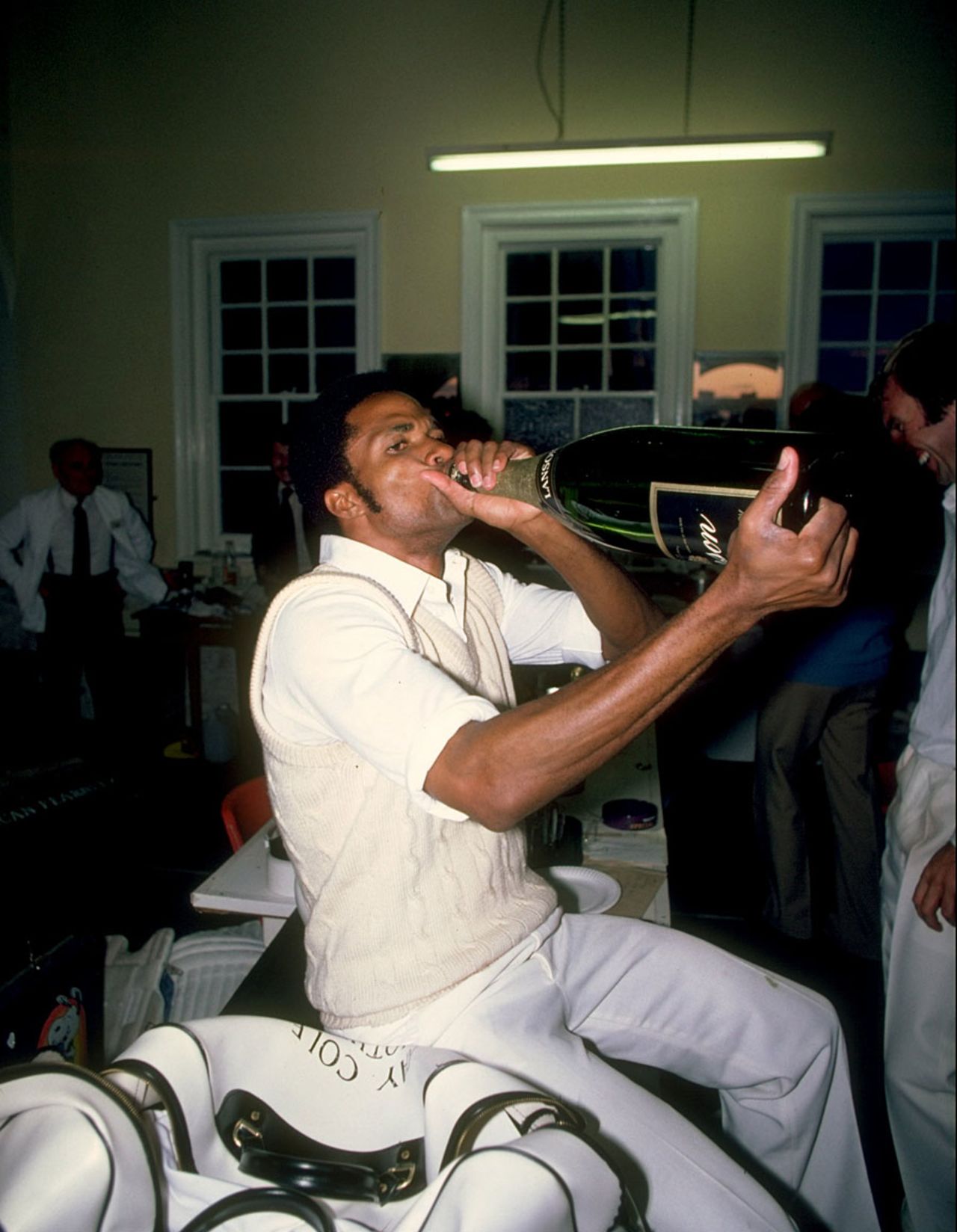 Norbert Phillips drinks champagne after a match, 1980