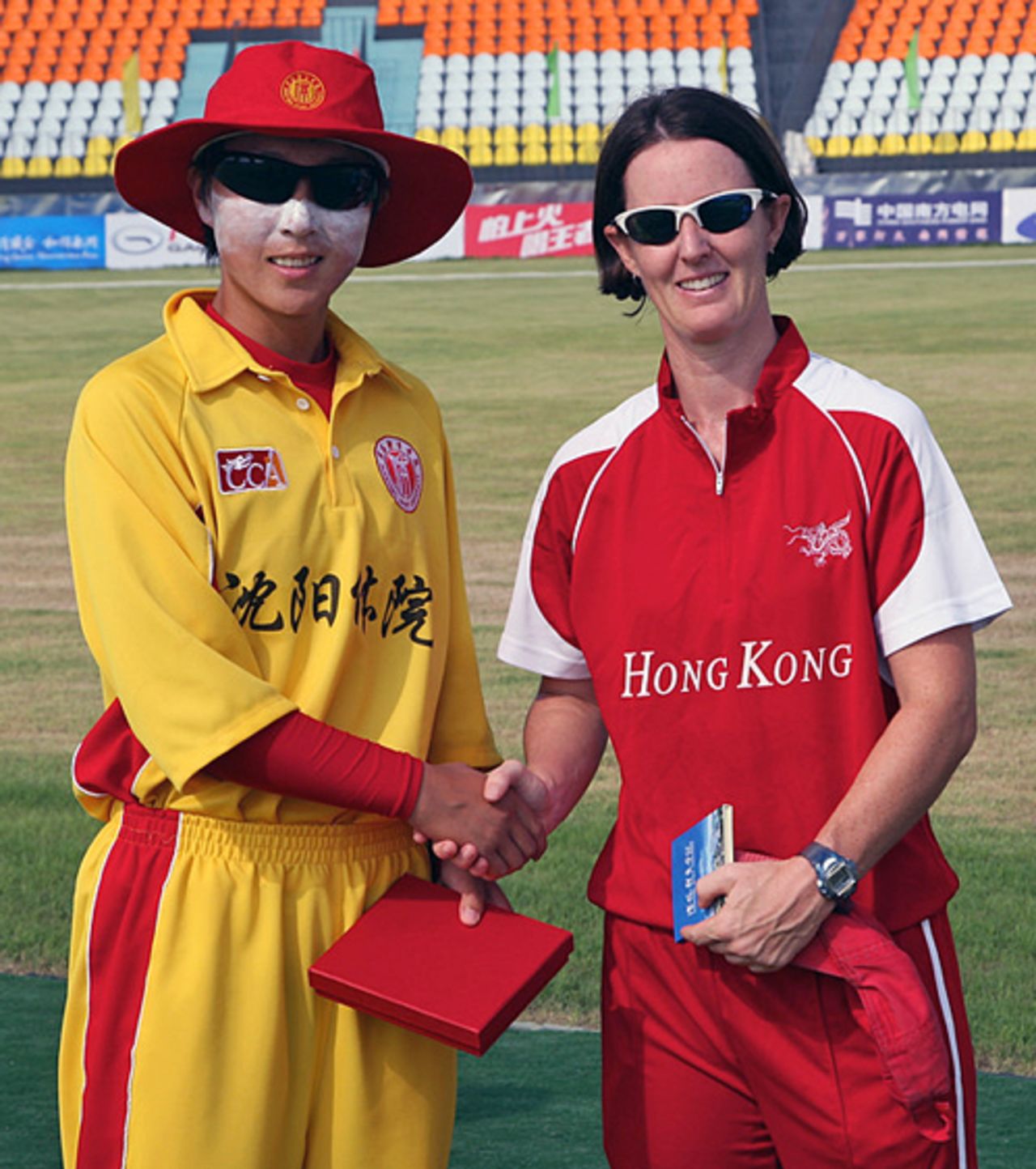 Shenyang University skipper Wang Meng and Hong Kong Women's skipper Neisha Pratt exchanges gifts before their match at the Guangzhou Cricket Stadium