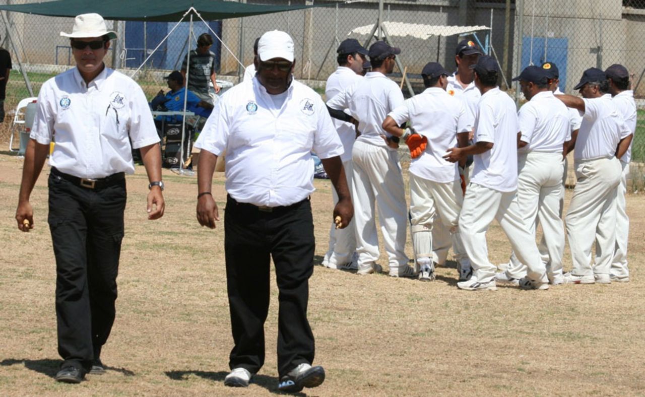 Lod huddle as umpires Chanan Sogavson and Arieh Razpurker (right) take the field