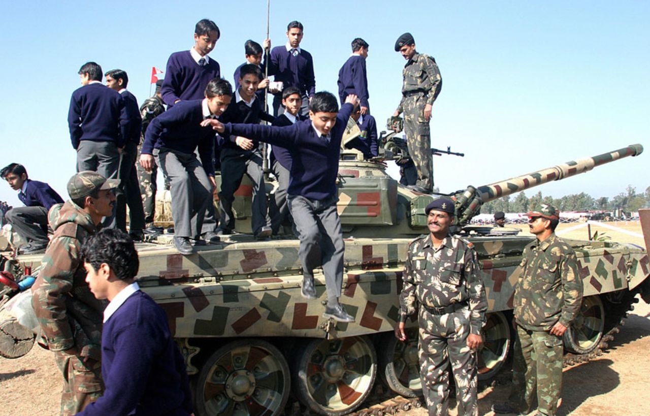 School children jump from a displayed T-72 tank during an exhibition, Chandigarh, January 6, 2006