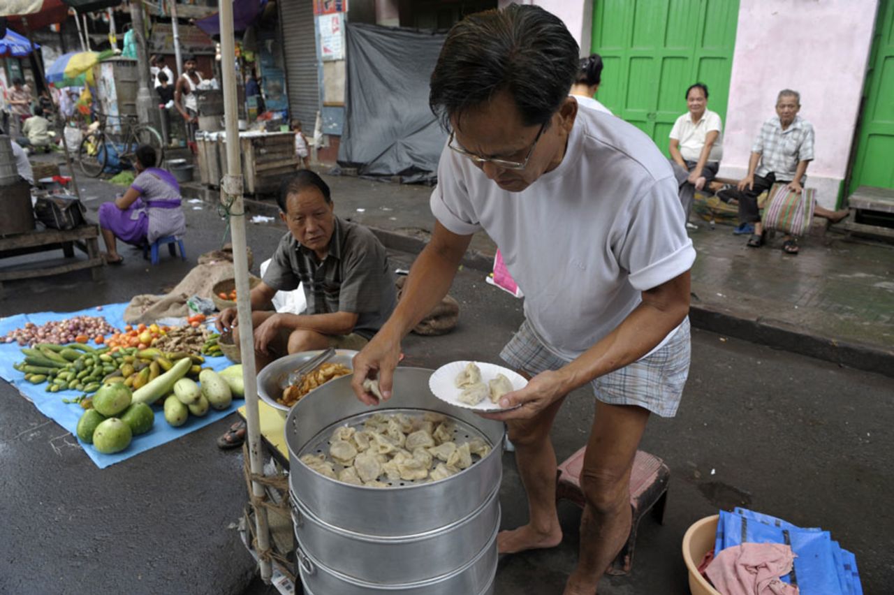 An Indian man of ethnic Chinese descent sells momos at a roadside breakfast stall in Territi Bazaar, Kolkata, July 26, 2010