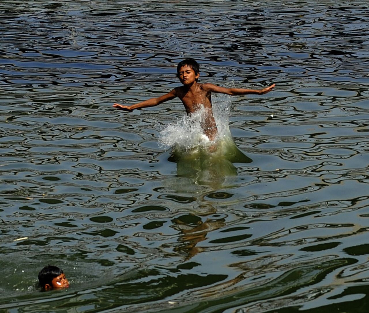 Children swim in the Buriganga river , Dhaka, May 7, 2010