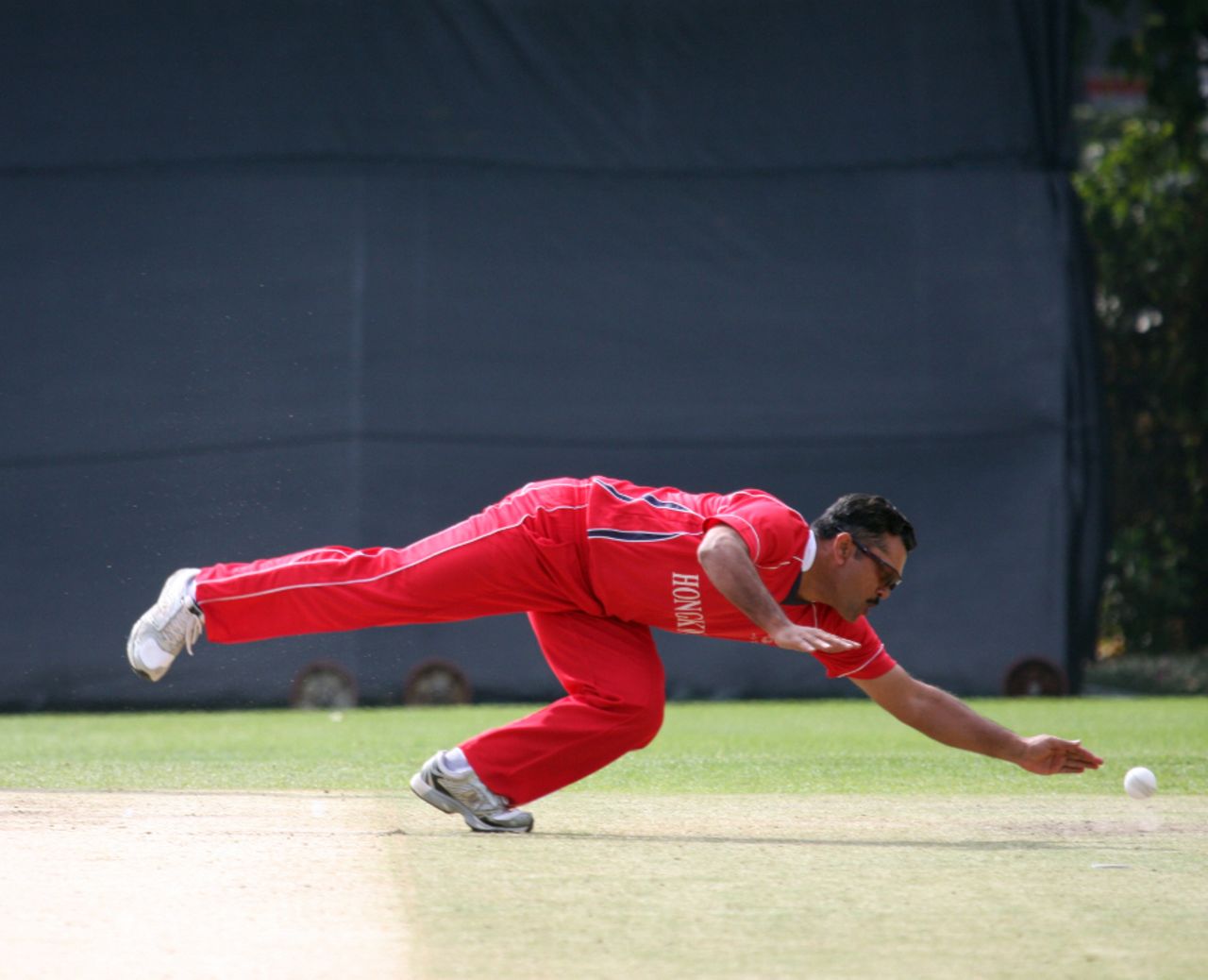 Munir Dar dives to field the ball off his own bowling during his parsimonious spell, Hong Kong v Papua New Guinea, WCL Division Three Final, Kowloon, January 29, 2011