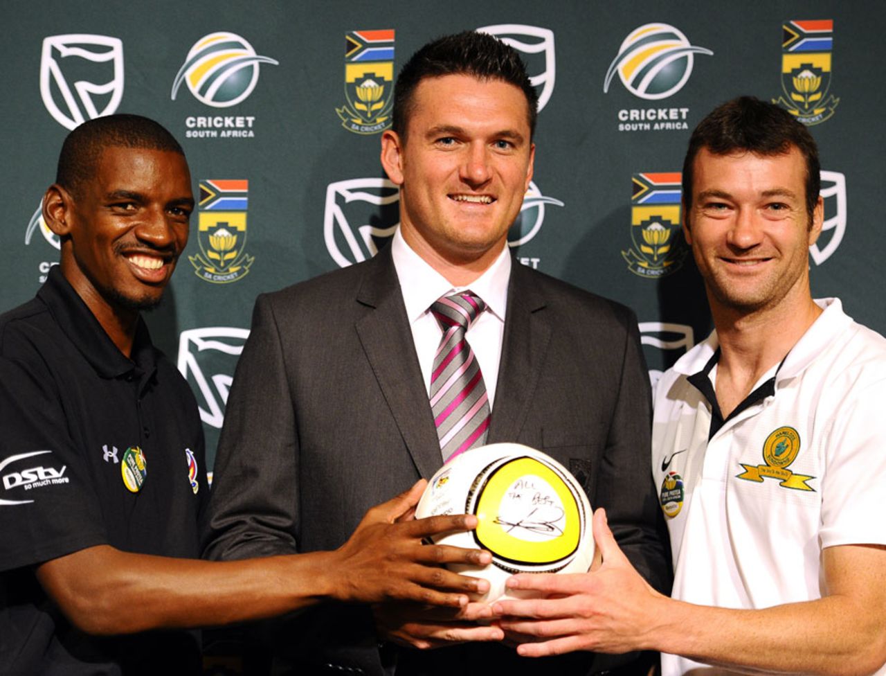 Graeme Smith receives a football from South African footballers Ricardo Katza and Calvin Marlin, Johannesburg, February 8, 2011