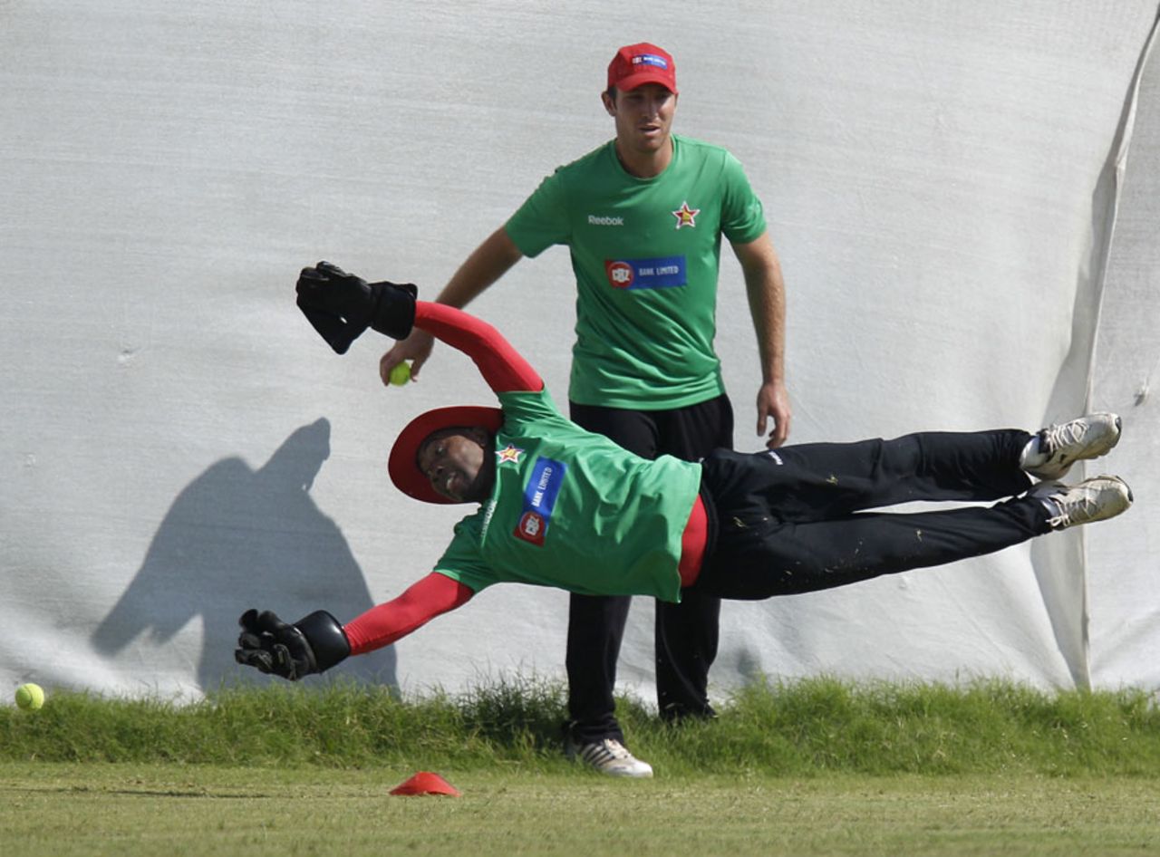 Tatenda Taibu dives during practice as Brendan Taylor looks on, Ahmedabad, February 18, 2011
