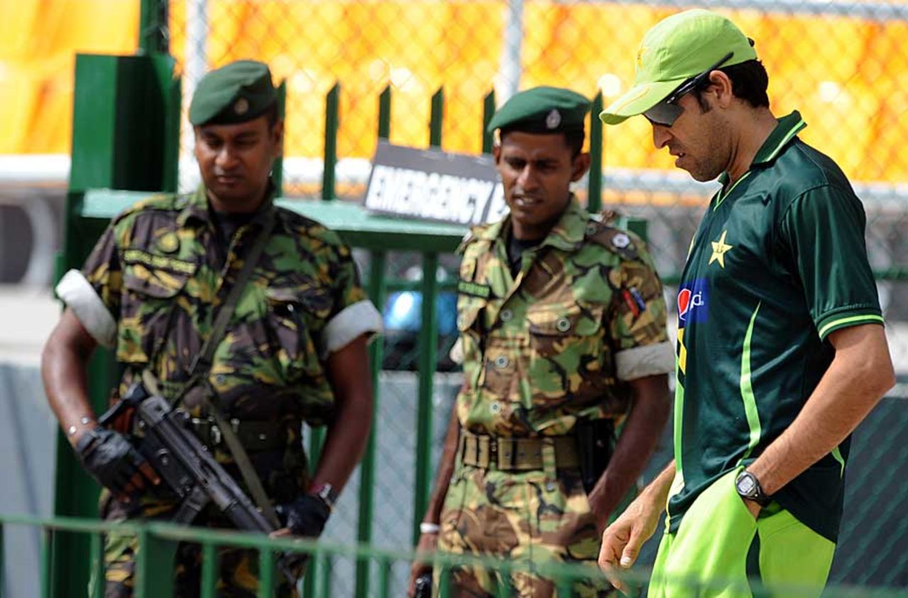 Umar Gul walks past security guards in Colombo, Colombo, February 25, 2011