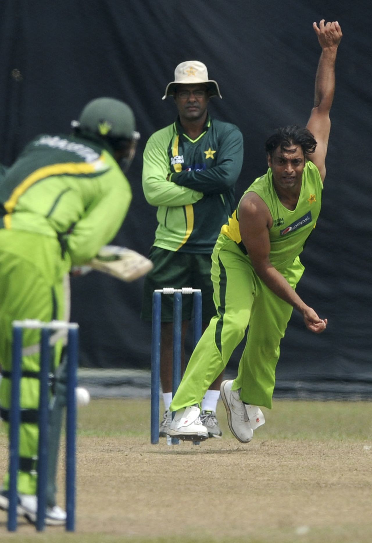 Shoaib Akhtar bowls during Pakistan's training session as Waqar Younis looks on, Colombo, February 28, 2011