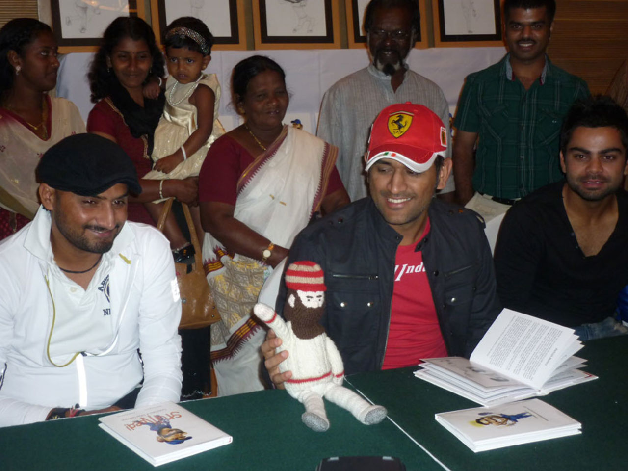MS Dhoni, sitting between Harbhajan Singh and Virat Kohli holds a WG Grace doll at a book launch, Bangalore, February 28, 2011