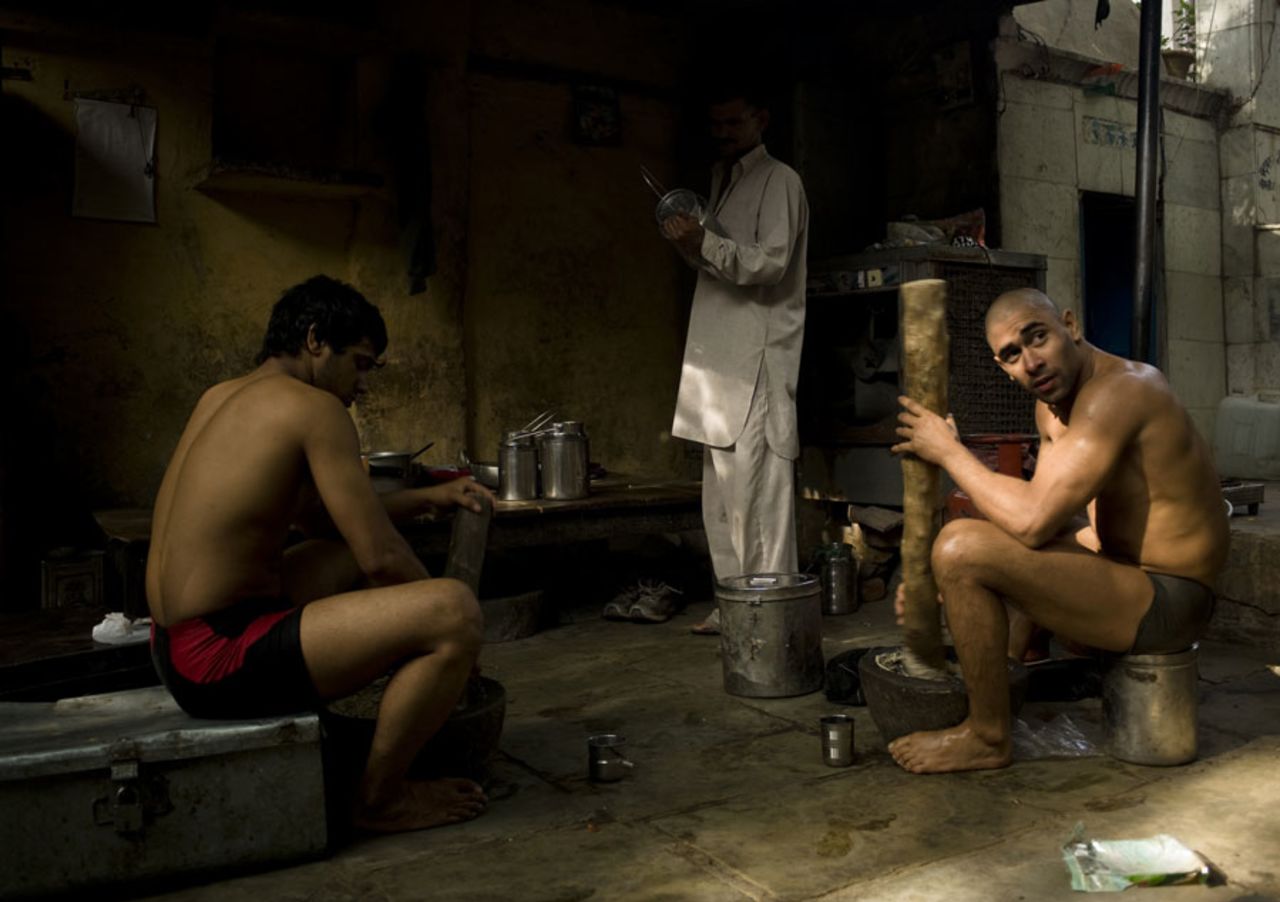 Indian wrestlers grind dry fruits in their wrestling school, the Guru Hanuman Akhara, Delhi, April 8, 2010