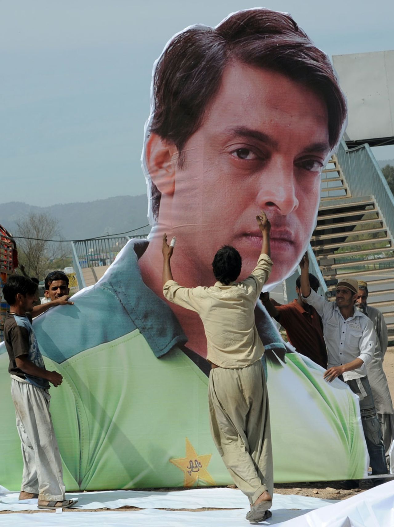Labourers erect a giant billboard of Shoaib Akhtar who will retire after the World Cup, Islamabad, March 21, 2011